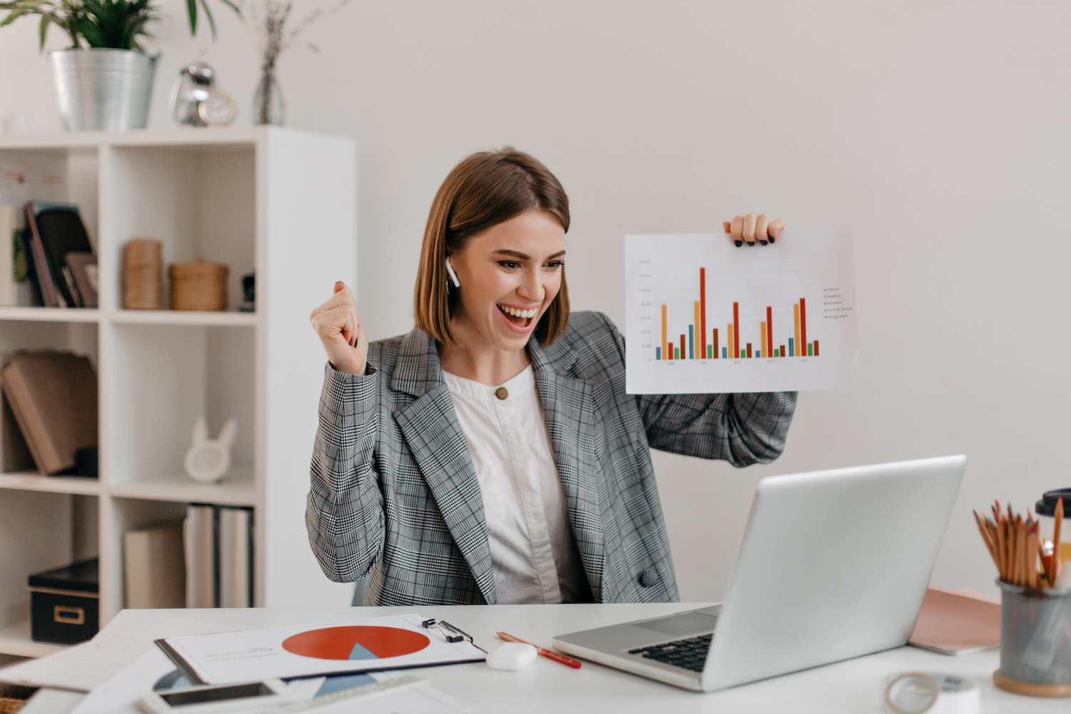 Close-up shot of happy business woman in stylish outfit. Girl in high spirits demonstrates chart via Skype. Measure Your Campaign's Success Elle Marketing and Events